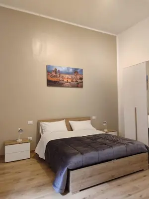 a bedroom with a bed and a painting on the wall at Casa di Tommy in Palermo