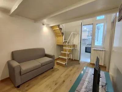 a living room with a couch and a staircase at Casa di Tommy in Palermo