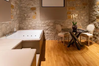 a bathroom with a tub and a table and chairs at Five suite in Palermo
