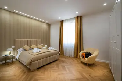 a bedroom with a bed and a chair at Palace Ducrot in Palermo