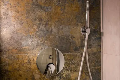a round mirror on a wall in a bathroom at Palace Ducrot in Palermo