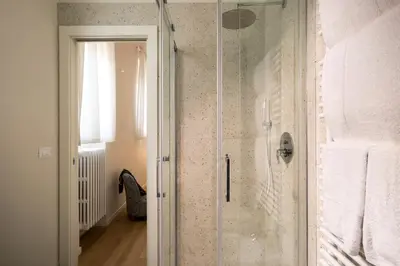 a shower with a glass door in a bathroom at Palace Ducrot in Palermo