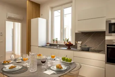 a kitchen with a table with food and wine glasses at Ducrot Apartment in Palermo