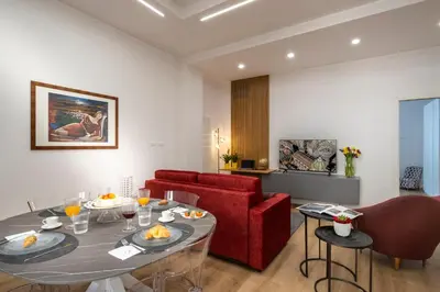 a living room with a table and a red couch at Ducrot Apartment in Palermo