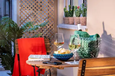 a table with two glasses of wine and a bowl of food at Ducrot Apartment in Palermo