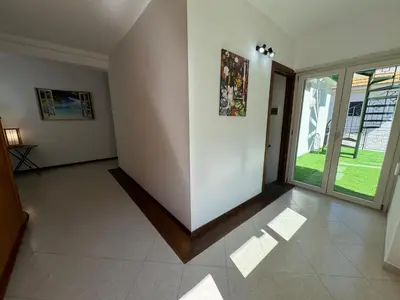 a living room with a large glass door and white walls at Mondello Luxury Apartment in Palermo