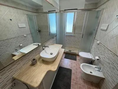 a bathroom with two sinks and a toilet and a mirror at Mondello Luxury Apartment in Palermo