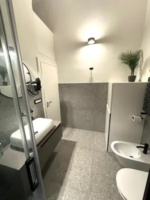 a bathroom with a sink and a toilet and a light at Cala Peppa Loft Butera in Palermo