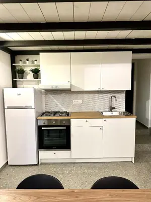 a kitchen with white cabinets and a sink at Cala Peppa Loft Butera in Palermo