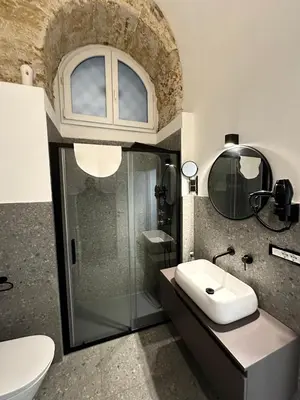 a bathroom with a sink and a glass shower at Cala Peppa Loft Butera in Palermo