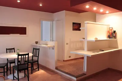 a dining room with a table and chairs and a counter at Apartment 
