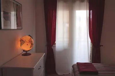 a bedroom with a window and a lamp on a dresser at Apartment 