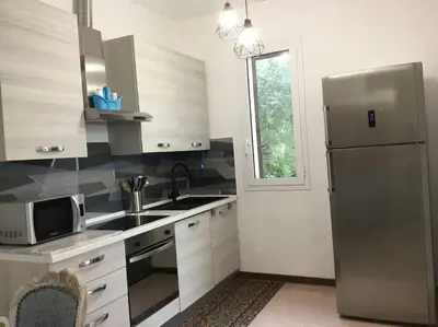 a kitchen with a stainless steel refrigerator and a window at Casa Amuri in Scopello