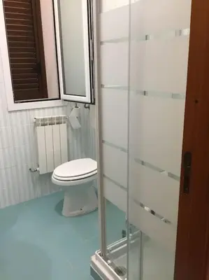 a bathroom with a toilet and a glass shower at Casa Amuri in Scopello