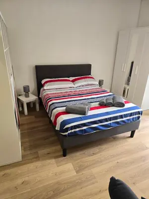 a bedroom with a bed with a striped blanket at Virginia House1 in Palermo