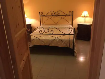 a bedroom with a bed and a lamp on a table at Villa Priscilla in Cinisi