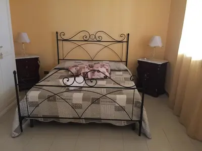 a bed in a room with two nightstands and a bed with a bed at Villa Priscilla in Cinisi