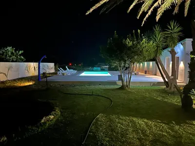 a backyard at night with a swimming pool at Villa Priscilla in Cinisi