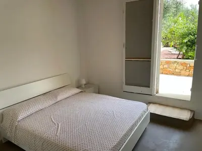 a bedroom with a bed and an open window at Scopello - Finestra sul cortile in Scopello