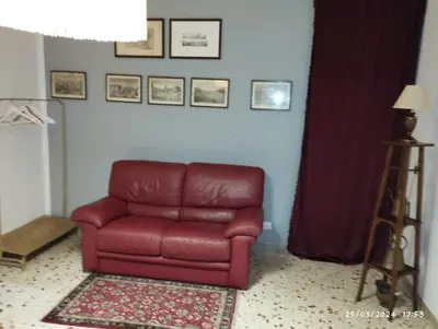 a red leather chair sitting in a living room at La casa di Nanà IL BAGLIO in Palermo