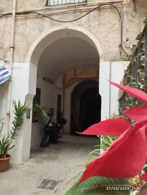 a motorcycle is parked in an archway in a building at La casa di Nanà IL BAGLIO in Palermo