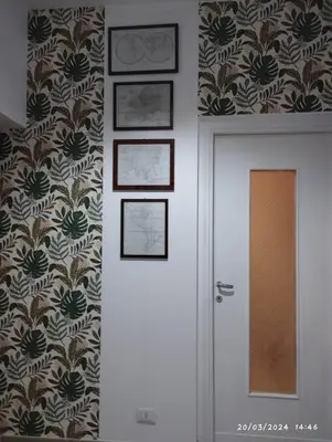 a hallway with a door and a wall with wallpaper at La casa di Nanà IL BAGLIO in Palermo