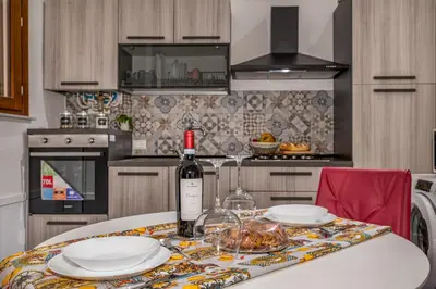 a kitchen with a table with a bottle of wine at Casa del Golfo Cascio in Castellammare del Golfo