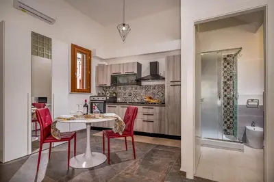 a kitchen with a table and red chairs in a room at Casa del Golfo Cascio in Castellammare del Golfo