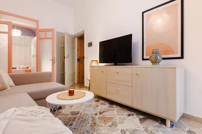 a living room with a couch and a tv on a cabinet at Ciao Sycylia Apartments in Carini
