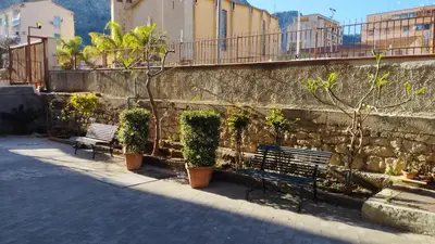two benches sitting next to a stone wall with plants at RineddaHouse Arenella - Vista Mare Panoramica a Palermo con Parcheggio privato in Palermo