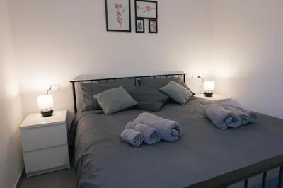 a bed with purple towels on it with two lamps at La casa di Louis in Palermo