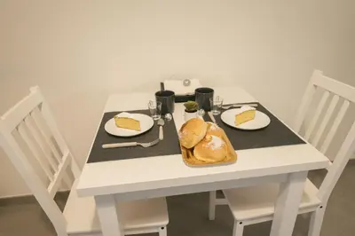 a white table with a plate of food on it at La casa di Louis in Palermo