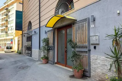 a store front with a yellow awning on a building at Molo Five Apartment in Palermo