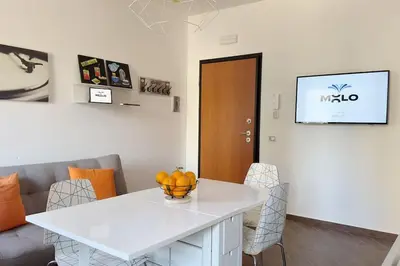 a dining room with a white table and chairs at Molo Five Apartment in Palermo