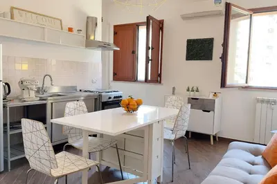 a kitchen with a white table and chairs in a room at Molo Five Apartment in Palermo
