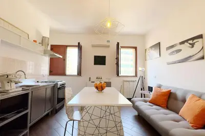 a kitchen and living room with a couch and a table at Molo Five Apartment in Palermo