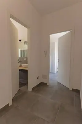 an empty room with two open doors and a kitchen at Panoramic apartment on the beach A/C in Palermo