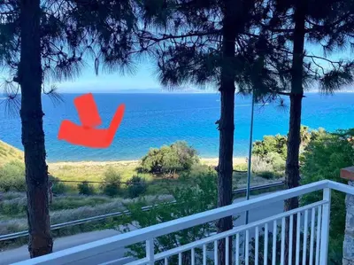 a red chair sitting on a balcony overlooking the ocean at Panoramic apartment on the beach A/C in Palermo
