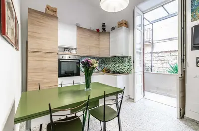 a kitchen with a green table and chairs at GuestHost - Near Palermo's Historic Heart - Apt with Courtyard in Palermo