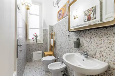 a bathroom with a sink and a toilet and a mirror at GuestHost - Near Palermo's Historic Heart - Apt with Courtyard in Palermo