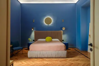 a blue bedroom with a bed with a yellow ball on it at Belmonte LR Collection in Palermo