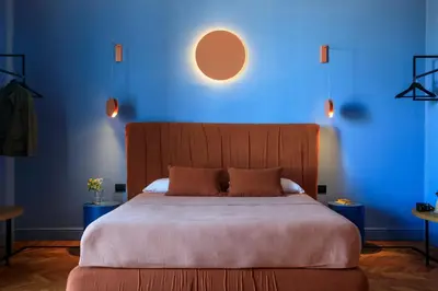 a bedroom with a large bed with a blue wall at Belmonte LR Collection in Palermo