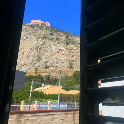 a view of a mountain from a window at Licia's home in Palermo