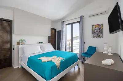 a bedroom with a blue bed and a blue chair at Luxury villa Taravilla with pool in Altavilla Milicia