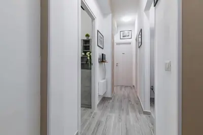 a hallway with white walls and wooden flooring at GuestHost - Palermo Charming Flat with Terraces x6 in Palermo