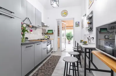 a kitchen with white cabinets and bar stools at GuestHost - Palermo Charming Flat with Terraces x6 in Palermo