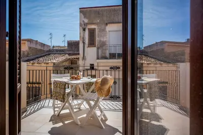 a table and chair on a balcony with a view at Casa Del Golfo SantAntonino in Castellammare del Golfo