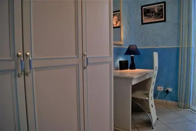 a room with a desk and a white cabinet and a table at la Maison 