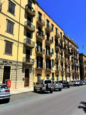 a large yellow building with cars parked in front of it at la Maison 