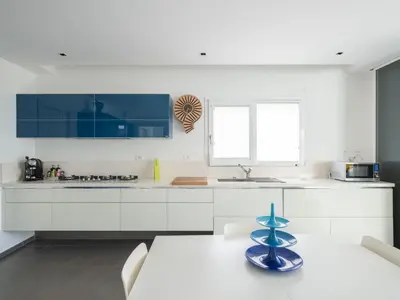 a kitchen with white cabinets and a blue bowl on a table at Villa Timpi Rossi Total Relax in Alcamo